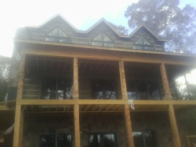 Dormers and porch framing on a large log home under construction — Roof Coating work by our crew in Taholah